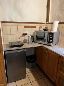 een keuken met een fornuis en een magnetron bij Magical Forest Cottage Escape! in Hogsback