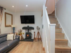 een woonkamer met een bank en een open haard bij Park View in Ambleside