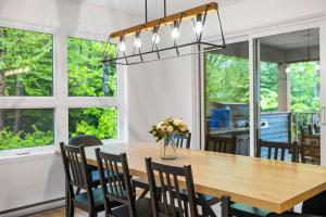 een eetkamer met een houten tafel en stoelen bij The Bear - Escapade en Nature avec Spa in Petite-Rivière-Saint-François