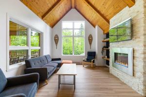 een woonkamer met een bank en een open haard bij The Bear - Escapade en Nature avec Spa in Petite-Rivière-Saint-François