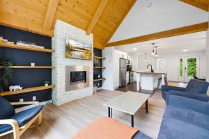 een woonkamer met een bank en een open haard bij The Bear - Escapade en Nature avec Spa in Petite-Rivière-Saint-François +19 foto's
