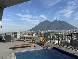 einen Balkon mit Bänken und Bergblick in der Unterkunft Bonito y cómodo loft en el centro de Monterrey! in Monterrey