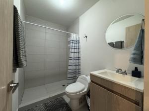 ein Badezimmer mit Toilette, Waschbecken und Spiegel in der Unterkunft Bonito y cómodo loft en el centro de Monterrey! in Monterrey