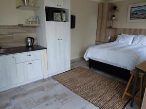 ein Schlafzimmer mit Bett und eine Küche mit Spüle in der Unterkunft Place of Old D in Eersterivier