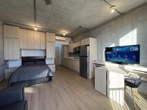 ein großes Zimmer mit einem Bett und einer Küche in der Unterkunft Bonito y cómodo loft en el centro de Monterrey! in Monterrey