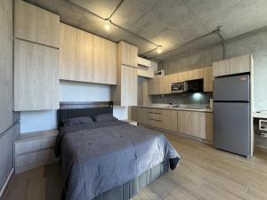 Schlafzimmer mit einem Bett, einem Kühlschrank und Schränken in der Unterkunft Bonito y cómodo loft en el centro de Monterrey! in Monterrey + 59 Fotos