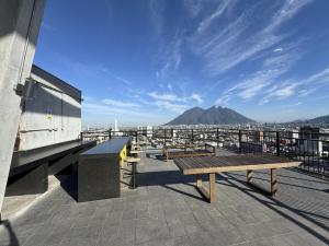 einer Holzbank auf dem Dach eines Gebäudes in der Unterkunft Bonito y cómodo loft en el centro de Monterrey! in Monterrey