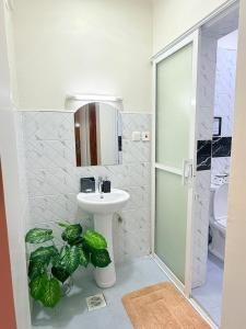 a bathroom with a sink and a glass shower at UrbanHive Naivasha Townhouse in Naivasha +14 photos