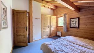 een slaapkamer met een bed in een houten kamer bij Chalets à Le Biot - Chalet Mon Frère MAE-4071 in Le Biot