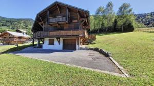 een groot houten huis bovenop een veld bij Chalets à Le Biot - Chalet Mon Frère MAE-4071 in Le Biot