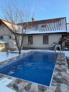 a swimming pool in the snow next to a house at Shahdag Suvacal House in Qusar