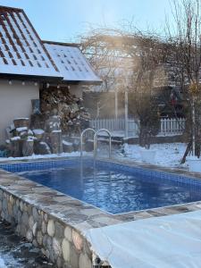 a swimming pool in a yard with snow on the ground at Shahdag Suvacal House in Qusar