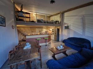 un soggiorno con un tavolo e un divano blu di Loft a Aujeurres
