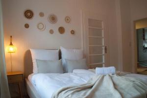a bedroom with a bed with white sheets and pillows at MS-Apartments I Quartier 4 in Leer +4 photos