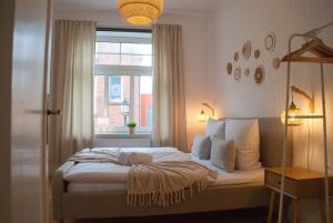 a bedroom with a bed with a window at MS-Apartments I Quartier 4 in Leer