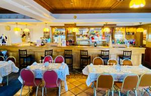 a restaurant with tables and chairs and a bar at The Lanterns Hotel in Tarbert +8 photos