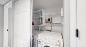 een kleine wasruimte met een wasmachine en droger bij Updated Two-Bedroom with Three King Beds Loft & Two Baths in Aurora