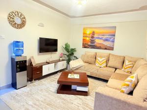 a living room with a couch and a tv at UrbanHive Naivasha Townhouse in Naivasha