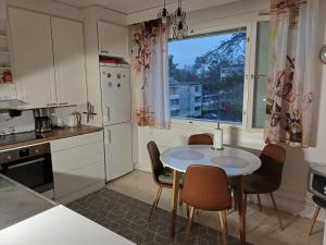a kitchen with a table and chairs and a window at Tilava kaksio Jussilankadulla in Hyvinkää