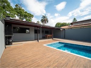 een achtertuin met een zwembad en een huis bij Piscina, Área Gourmet, Wi-fi e Garagem in Pirassununga +8 foto's