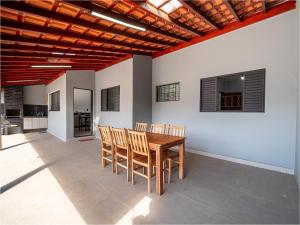 een eetkamer met een houten tafel en stoelen bij Piscina, Área Gourmet, Wi-fi e Garagem in Pirassununga