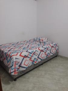 a bed with a colorful quilt on top of it at Apto central 3 hab in Apartadó