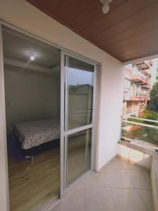 een balkon met een schuifpui met een bed bij Apartamento 150m das Termas in Piratuba