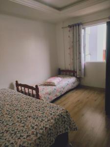 een slaapkamer met twee bedden en een groot raam bij Apartamento 150m das Termas in Piratuba