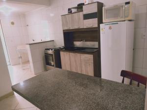 een keuken met een witte koelkast en een aanrecht bij Apartamento 150m das Termas in Piratuba +5 foto's