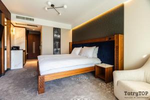 een slaapkamer met een groot bed en een bank bij TatryTop Giewont House in Kościelisko