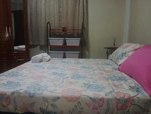 a bedroom with a bed with a floral bedspread at J's vacation home in Wallhouse