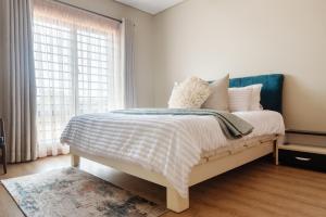 a bedroom with a bed and a window at charming retreat in Gaborone