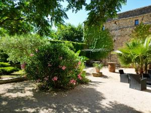 een tuin met een grote bush met roze bloemen bij Maison d'hôte Mas de Castille entre Uzès et le pont du Gard in Argilliers