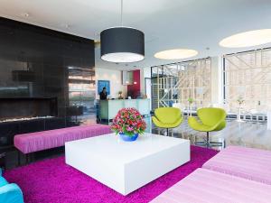 a lobby with a white table and green chairs at Hotel bh Parque 93 in Bogotá