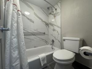 ein Badezimmer mit einem WC, einer Badewanne und einer Toilettenpapier in der Unterkunft Red Roof Inn Arlington - Entertainment District in Arlington + 38 Fotos