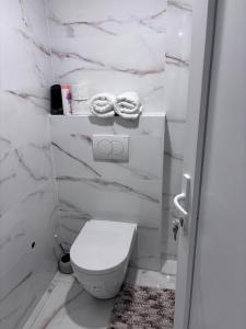 a white bathroom with a toilet and marble walls at corly1 in Vétraz-Monthoux