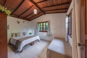 una camera da letto con un letto e una finestra di Pousada Arraial dos Sonhos a Arraial d'Ajuda Altre 40 foto