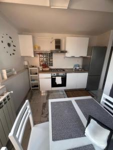 een kleine keuken met witte kasten en een tafel bij Terrazza Appia 112 in Potenza +2 foto's