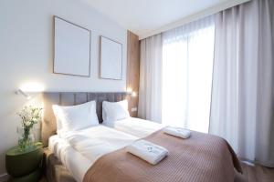a bedroom with a large bed with two towels on it at Laguna Beskidów Resort - Desert Spring in Zarzecze
