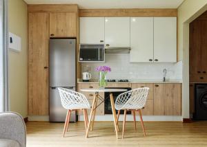 a kitchen with a table and chairs and a refrigerator at charming retreat in Gaborone