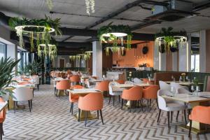 a restaurant with tables and chairs and plants at Laguna Beskidów Resort - Desert Spring in Zarzecze