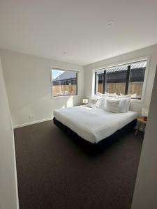 een slaapkamer met een groot bed met witte lakens en kussens bij Remarkable View with Outdoor Hot Tub in Frankton