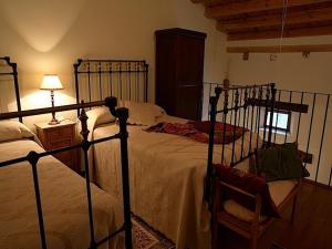 1 dormitorio con 2 camas, lámpara y silla en Posada Molino del Canto, en Barriolacuesta