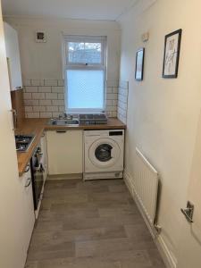 eine kleine Küche mit einer Waschmaschine und einem Fenster in der Unterkunft Duncan - 2Bdrm Sleeps 5 Good for Contractors in Gateshead