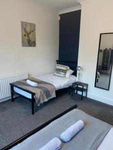ein Schlafzimmer mit zwei Betten und einem Spiegel in der Unterkunft Duncan - 2Bdrm Sleeps 5 Good for Contractors in Gateshead