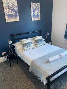 ein Schlafzimmer mit einem großen Bett mit blauen Wänden in der Unterkunft Duncan - 2Bdrm Sleeps 5 Good for Contractors in Gateshead + 11 Fotos