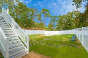 a yard with a white fence and a chair at Ocean Pearl in Kill Devil Hills
