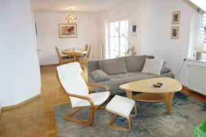 a living room with a couch and a table and chairs at FEWO EMMA in Overath