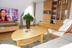 a living room with a table and a tv at FEWO EMMA in Overath