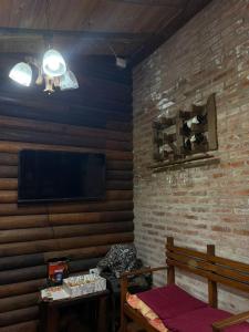 un soggiorno con TV e muro di mattoni di casa quinta los teritos ad Abasto